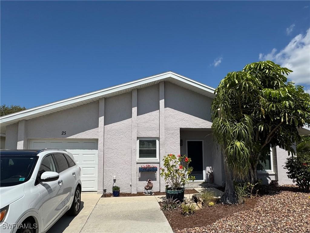 exterior space with an attached garage, driveway, and stucco siding