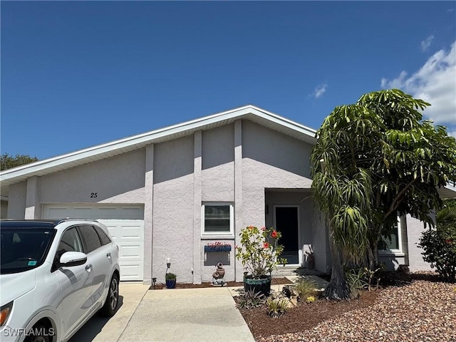 exterior space with an attached garage, driveway, and stucco siding