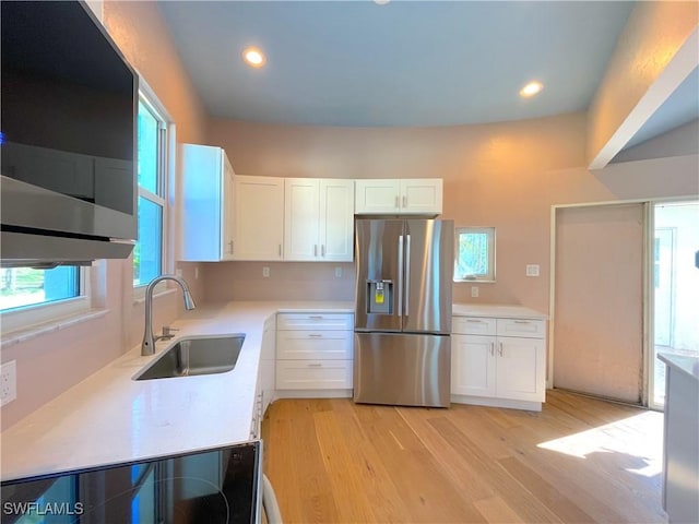 kitchen with white cabinets, appliances with stainless steel finishes, light countertops, and a sink