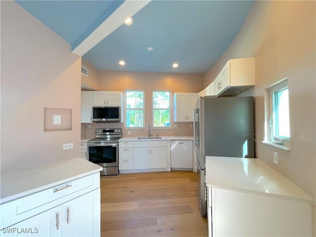 kitchen with light wood-type flooring, visible vents, appliances with stainless steel finishes, and white cabinets