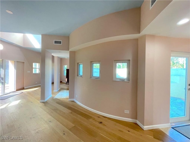 corridor with visible vents, baseboards, and light wood finished floors