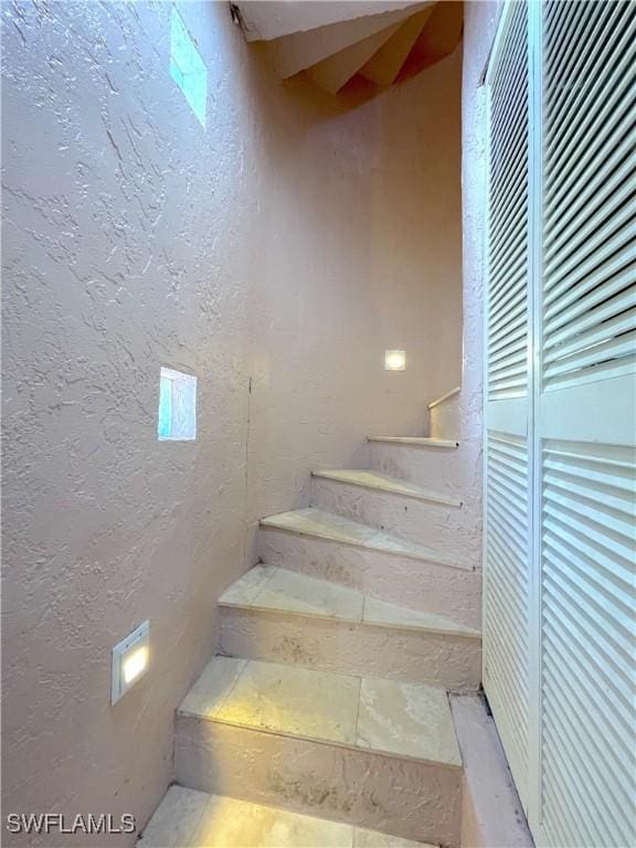 staircase with a textured wall