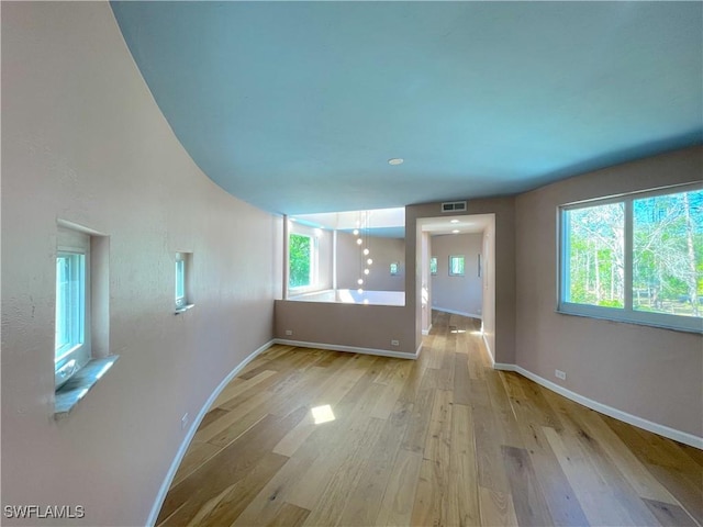 interior space featuring a wealth of natural light, visible vents, light wood-style flooring, and baseboards