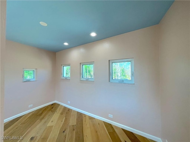 empty room featuring recessed lighting, light wood-type flooring, and baseboards