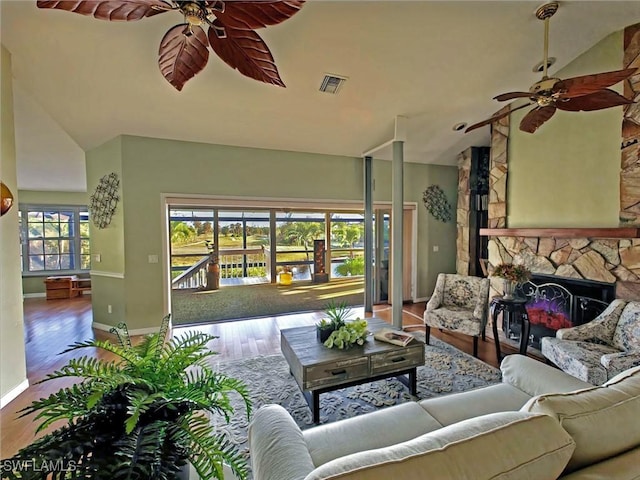 living area with wood finished floors, a ceiling fan, visible vents, and baseboards