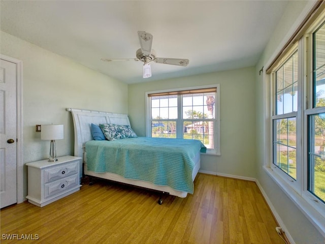 bedroom with baseboards, light wood finished floors, and ceiling fan