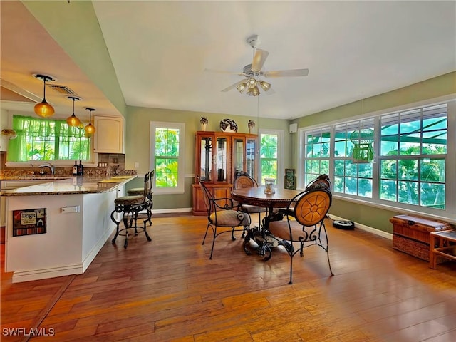 dining room with baseboards, a ceiling fan, and hardwood / wood-style floors