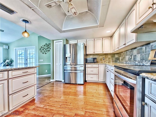 kitchen featuring visible vents, backsplash, under cabinet range hood, light wood-type flooring, and appliances with stainless steel finishes