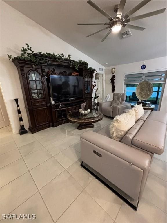 living room with light tile patterned floors, visible vents, a ceiling fan, and vaulted ceiling