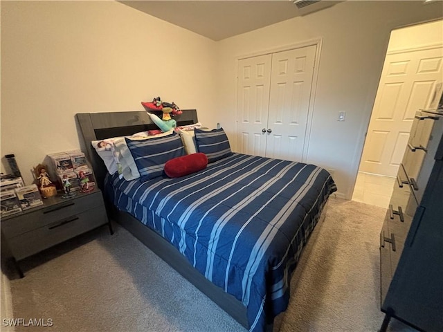 bedroom with a closet, visible vents, and carpet flooring