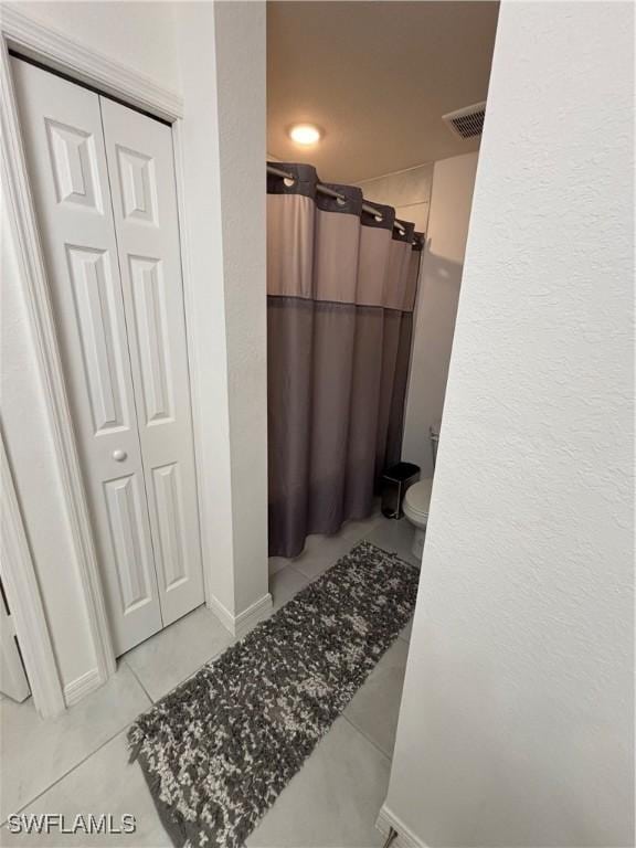 full bathroom featuring tile patterned flooring, visible vents, curtained shower, and toilet