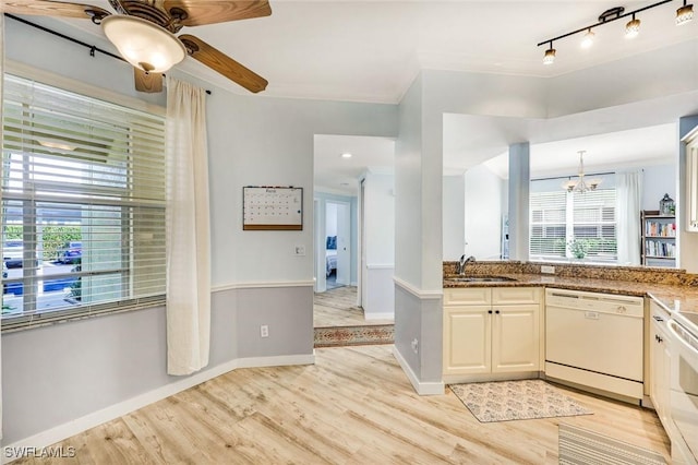 kitchen featuring baseboards, light wood finished floors, white dishwasher, a sink, and crown molding