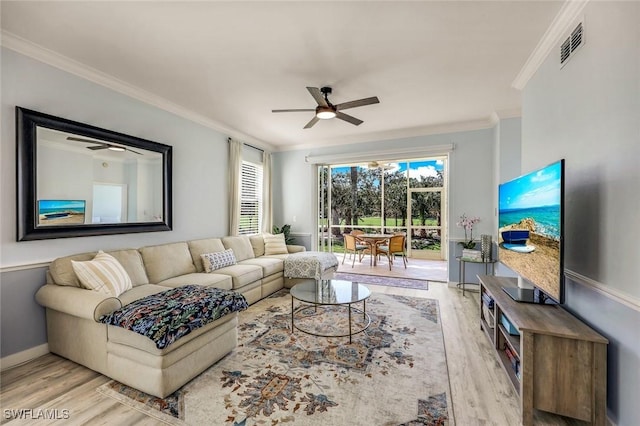 living room featuring visible vents, baseboards, ornamental molding, wood finished floors, and a ceiling fan