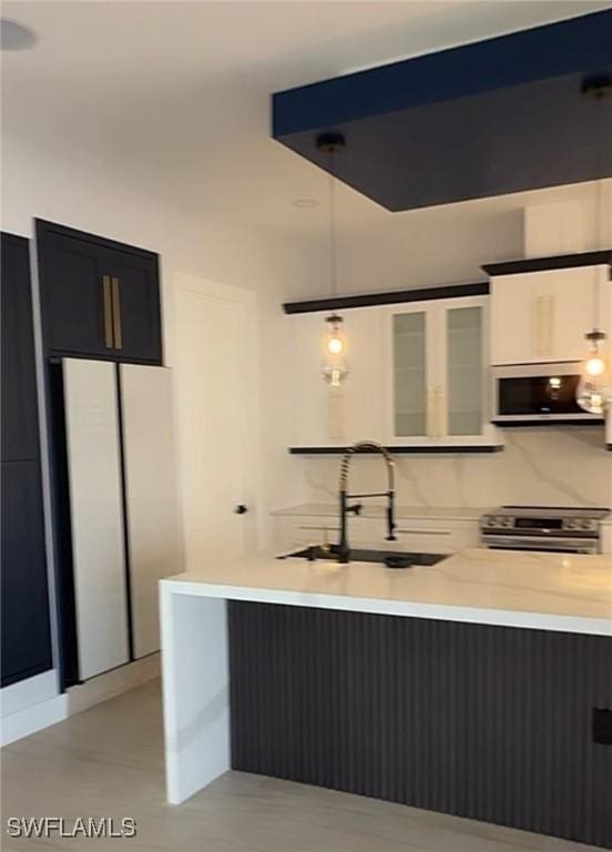 kitchen with a sink, stainless steel appliances, and light countertops