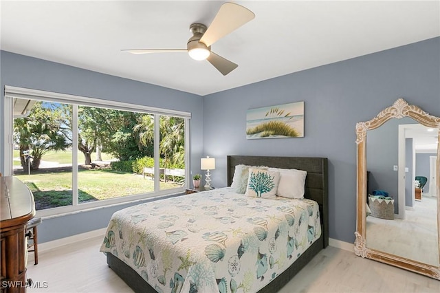 bedroom with baseboards, wood finished floors, and a ceiling fan