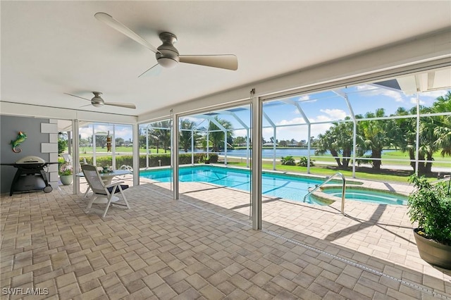 view of pool with glass enclosure, a patio area, a pool with connected hot tub, and ceiling fan