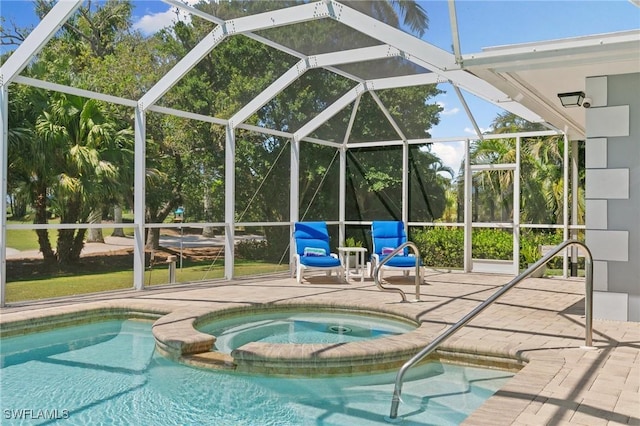 view of pool with glass enclosure, a pool with connected hot tub, and a patio