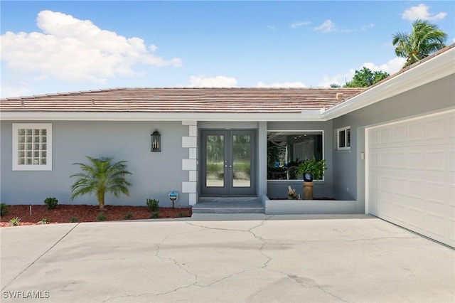 entrance to property with french doors, a tile roof, and stucco siding