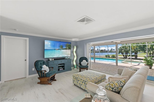 living area featuring visible vents, wood finished floors, baseboards, and ornamental molding