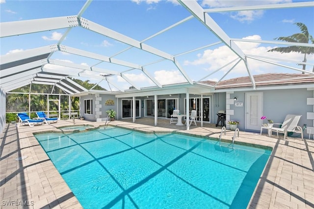 view of swimming pool featuring a lanai, a pool with connected hot tub, and a patio