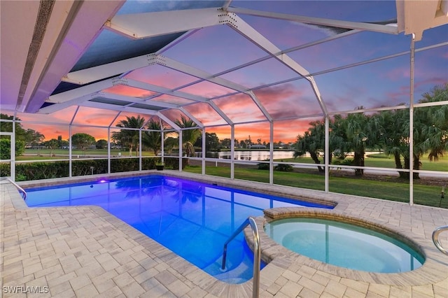 view of pool featuring a patio area, glass enclosure, and a pool with connected hot tub