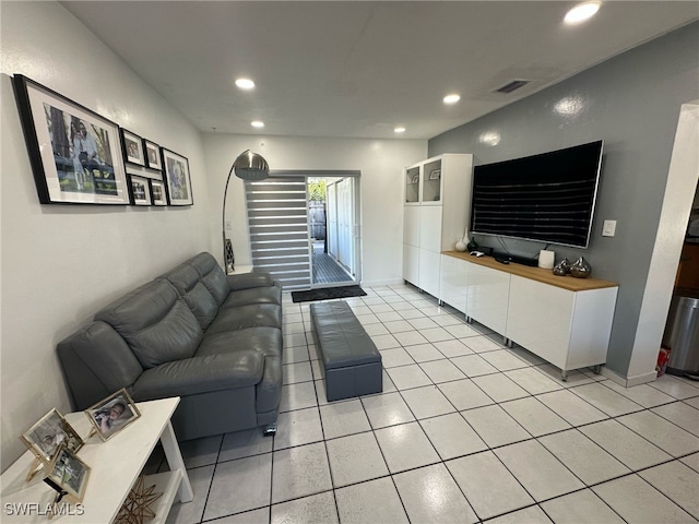 living area featuring light tile patterned flooring, recessed lighting, visible vents, and baseboards