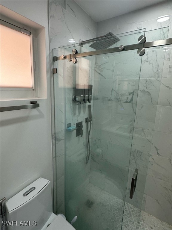 full bath featuring a marble finish shower and toilet