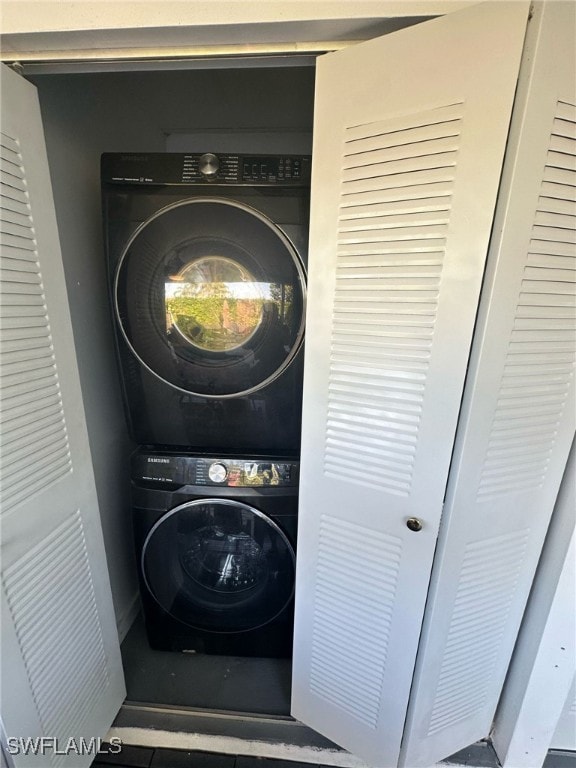 clothes washing area with laundry area and stacked washer and dryer