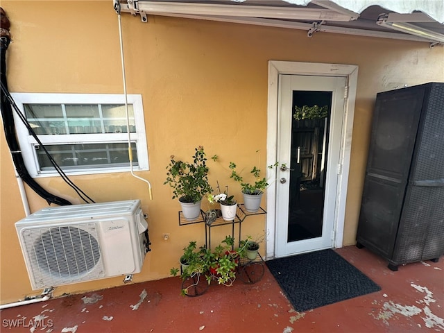 doorway to property featuring stucco siding and ac unit