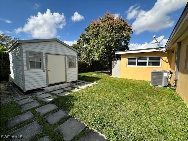 view of yard with an outbuilding, central air condition unit, and a shed