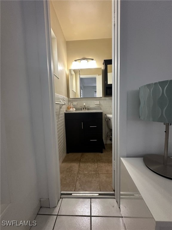 bathroom featuring vanity, tile patterned floors, toilet, and tile walls