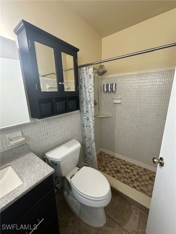 bathroom featuring vanity, a tile shower, decorative backsplash, tile patterned floors, and toilet