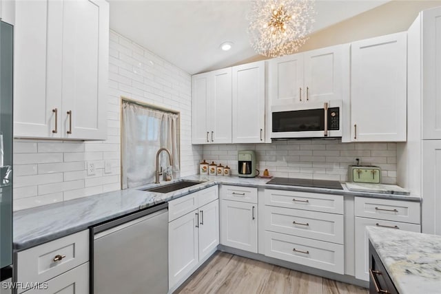 17450 Taylor Rd, Alva, FL 33920 - kitchen with a sink, dishwashing machine, black electric stovetop, white microwave, and vaulted ceiling