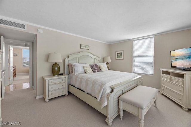 bedroom featuring light carpet, visible vents, multiple windows, and ornamental molding