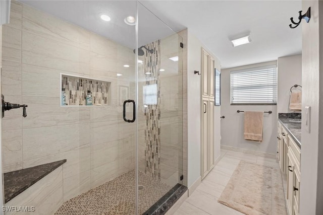 full bathroom with vanity, a shower stall, and baseboards