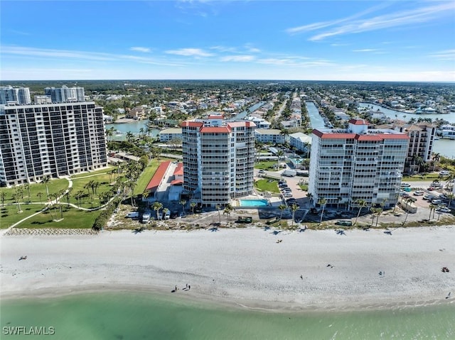 drone / aerial view with a water view, a city view, and a beach view