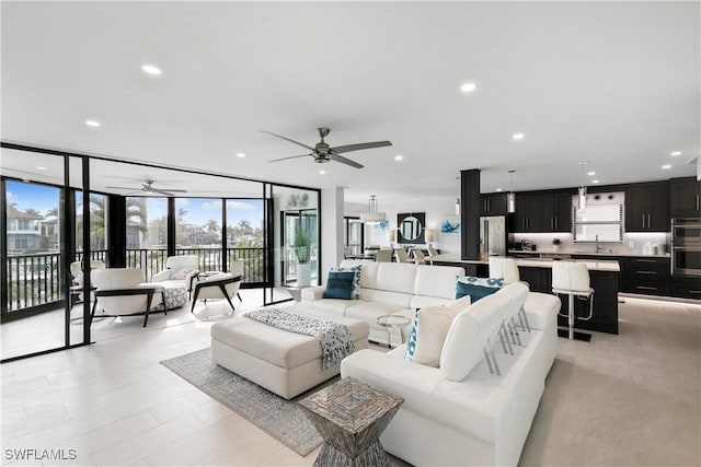 living area featuring a wall of windows, recessed lighting, and ceiling fan