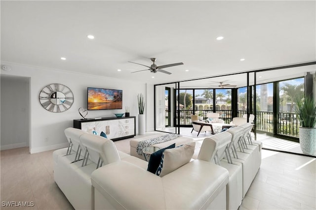 living area featuring recessed lighting, a ceiling fan, baseboards, and expansive windows