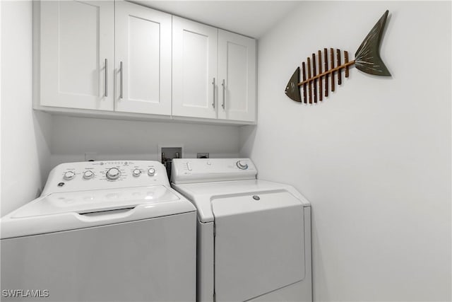 washroom featuring cabinet space and washing machine and clothes dryer