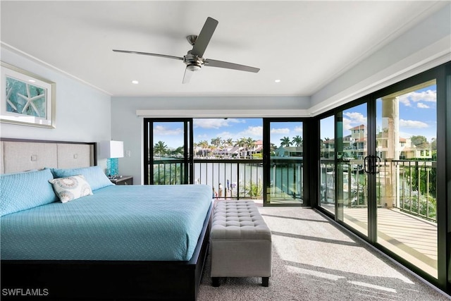 carpeted bedroom with multiple windows, a water view, access to exterior, and a ceiling fan