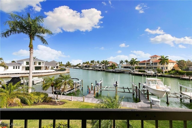 dock area featuring boat lift, a residential view, and a water view