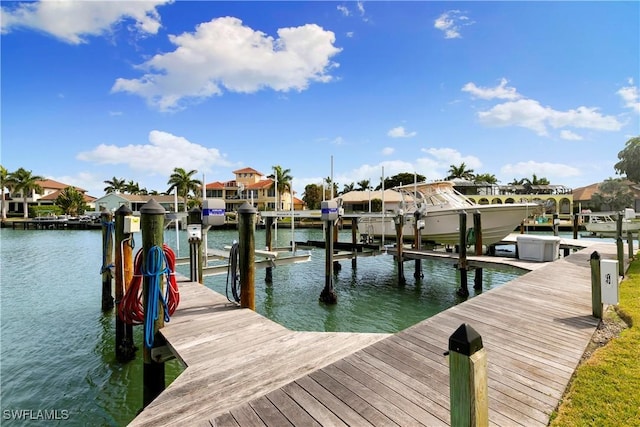 dock area with a water view, a residential view, and boat lift