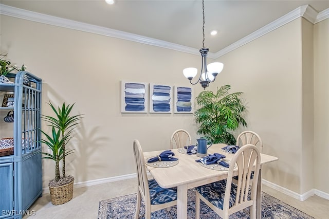 dining room featuring a notable chandelier, baseboards, carpet floors, and ornamental molding