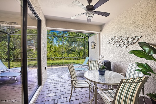 sunroom / solarium featuring ceiling fan