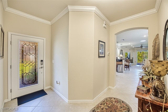 entrance foyer featuring light tile patterned floors, arched walkways, and ornamental molding