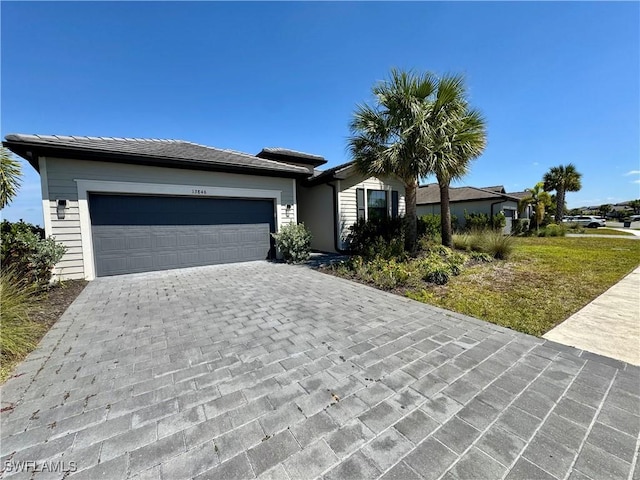 ranch-style house featuring decorative driveway and an attached garage