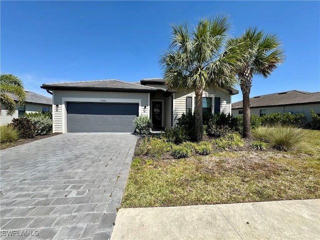 ranch-style house with decorative driveway and a garage