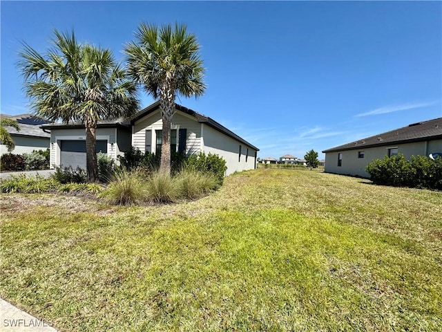 view of home's exterior with an attached garage, driveway, and a yard