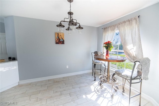 dining room featuring baseboards, a healthy amount of sunlight, and a chandelier