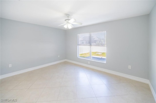 spare room featuring light tile patterned floors, baseboards, and ceiling fan